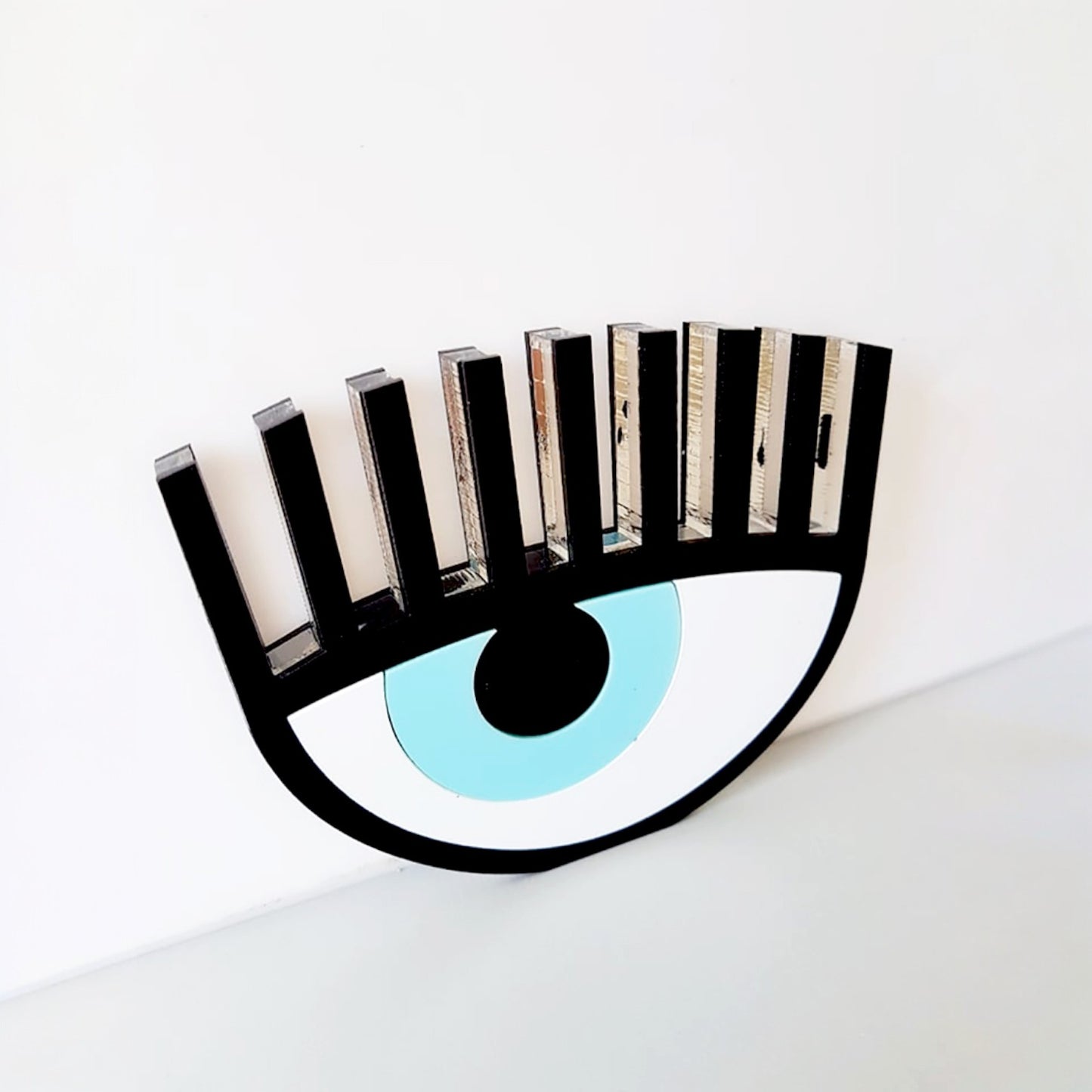 Handmade black plexiglass evil eye table charm with lashes on neutral background – So Cute by Dimi.