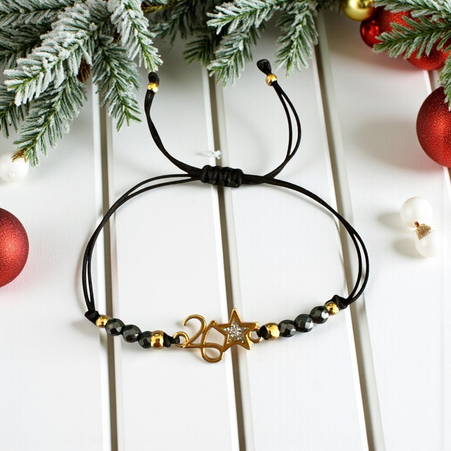 Χειροποίητο βραχιόλι γούρι 2026 με αιματίτη & αστεράκι glitter σε κορδόνι – So Cute by Dimi Wholesale