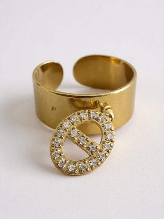 Χρυσό ατσάλινο δαχτυλίδι με charm διακοσμημένο με λευκά στρας σε λευκό φόντο