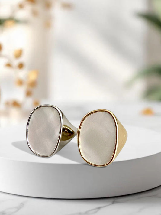 Gold and silver adjustable ring with mother of pearl-style oval top on white display background.