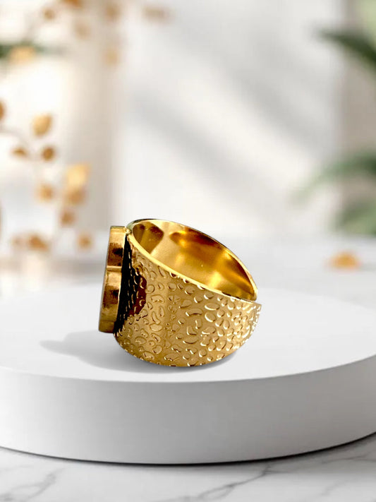 Gold hammered adjustable ring with white clover-shaped mother of pearl on white background, perfect for boho-chic styling.