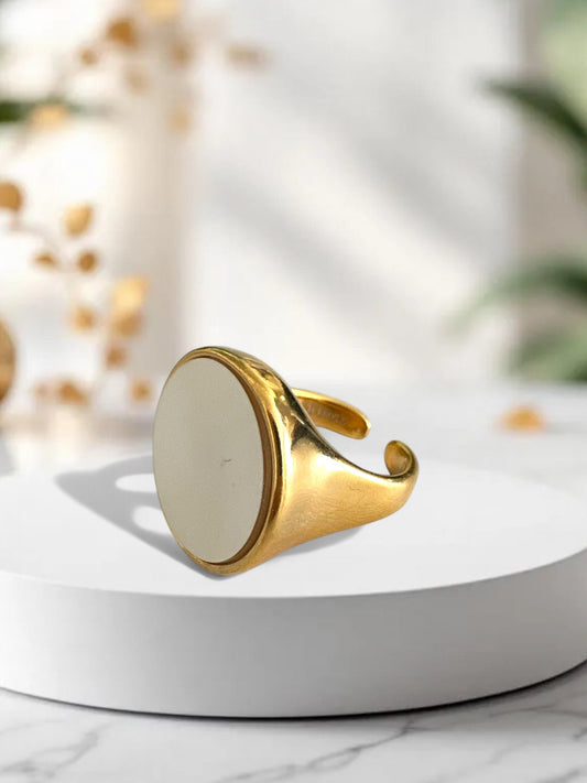 Ατσάλινο δαχτυλίδι σε χρυσό με mother of pearl κυκλικό στοιχείο, σε λευκό φόντο.