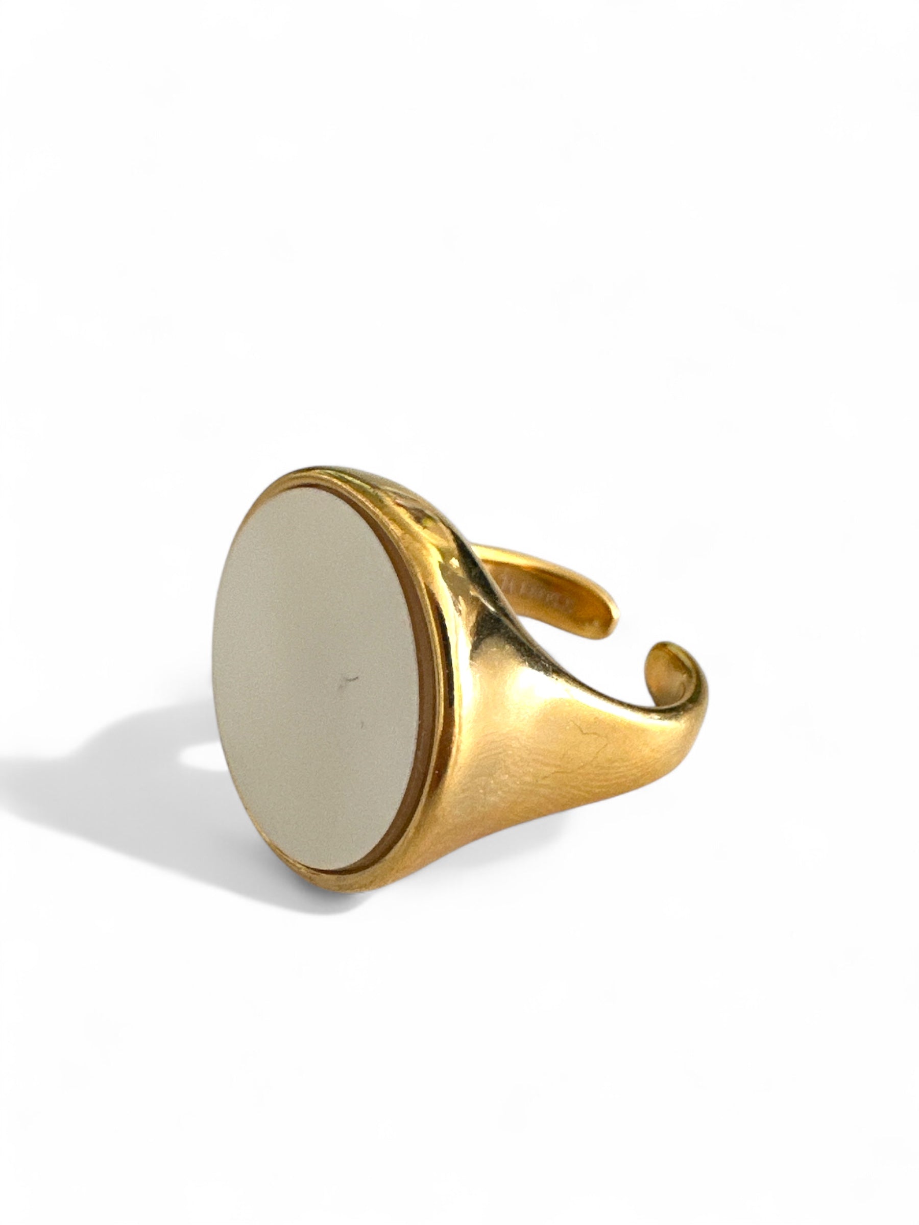 Ατσάλινο δαχτυλίδι σε χρυσό με mother of pearl κυκλικό στοιχείο, σε λευκό φόντο.