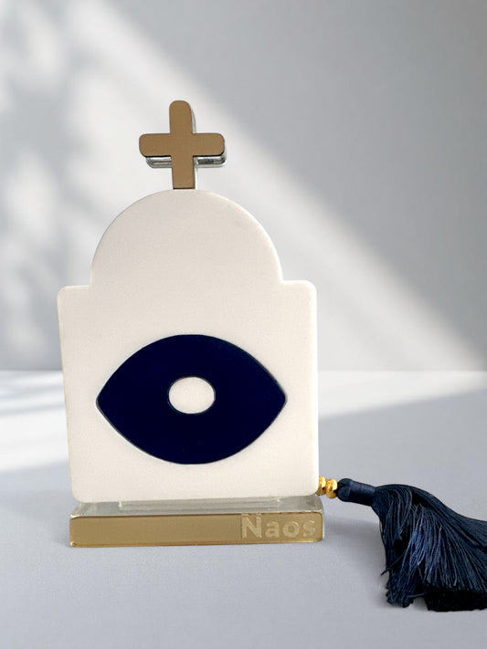 Γούρι plexiglass σε σχήμα ναού με navy μάτι, χρυσό σταυρό και μπλε φούντα – design αντικείμενο ελληνικής έμπνευσης
