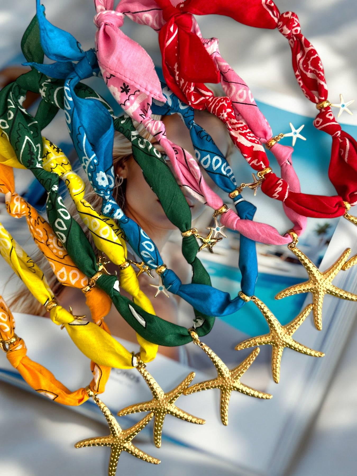 Colorful bandana necklaces with starfish decorations on a white background
