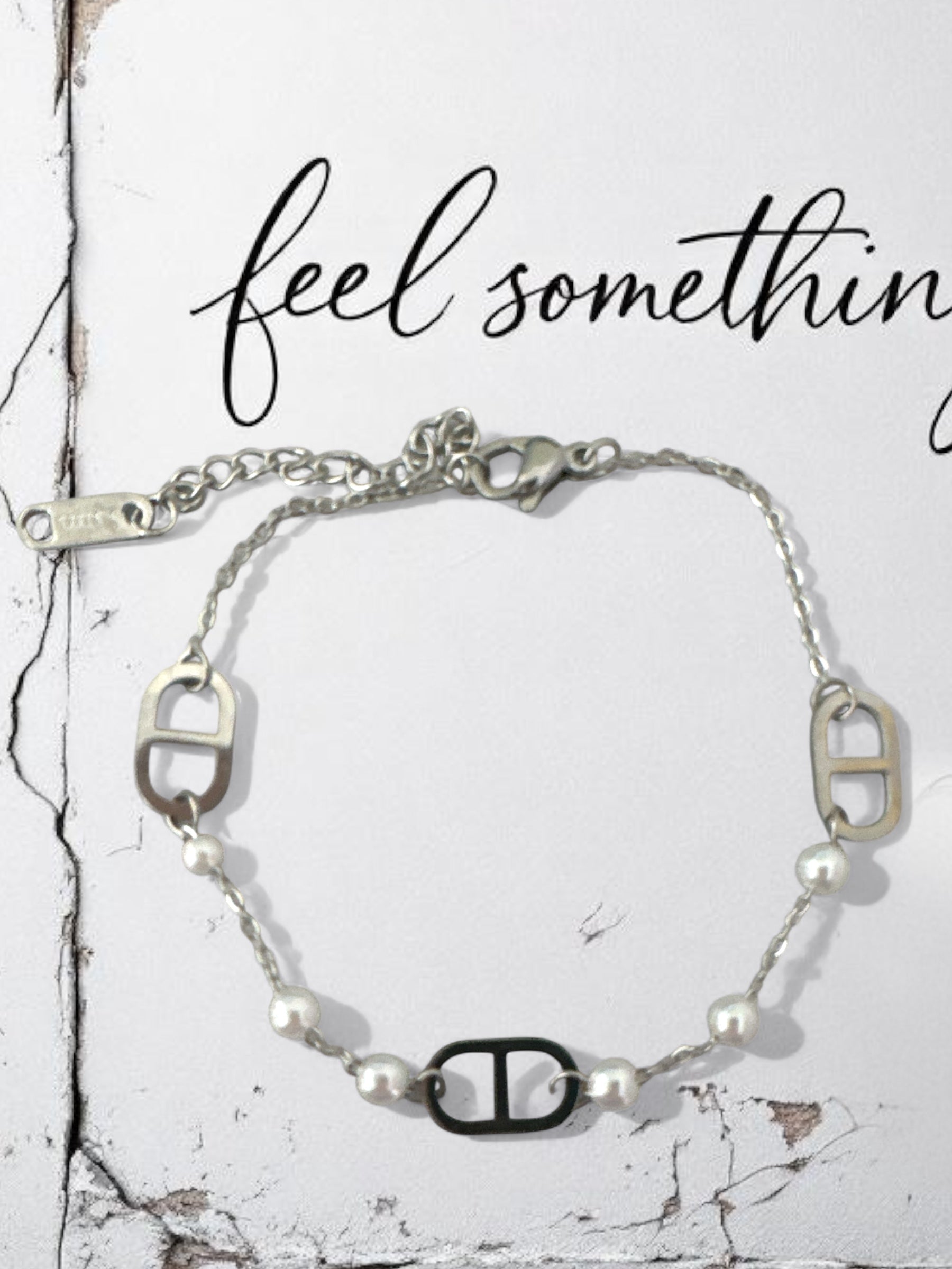 Silver bracelet with pearls on a textured white background