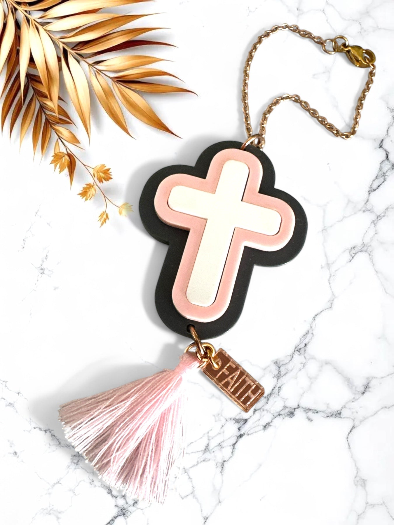 Γούρι αυτοκινήτου σταυρός σε blush pink και γκρι πλέξιγκλας με φούντα και  charm “Faith”