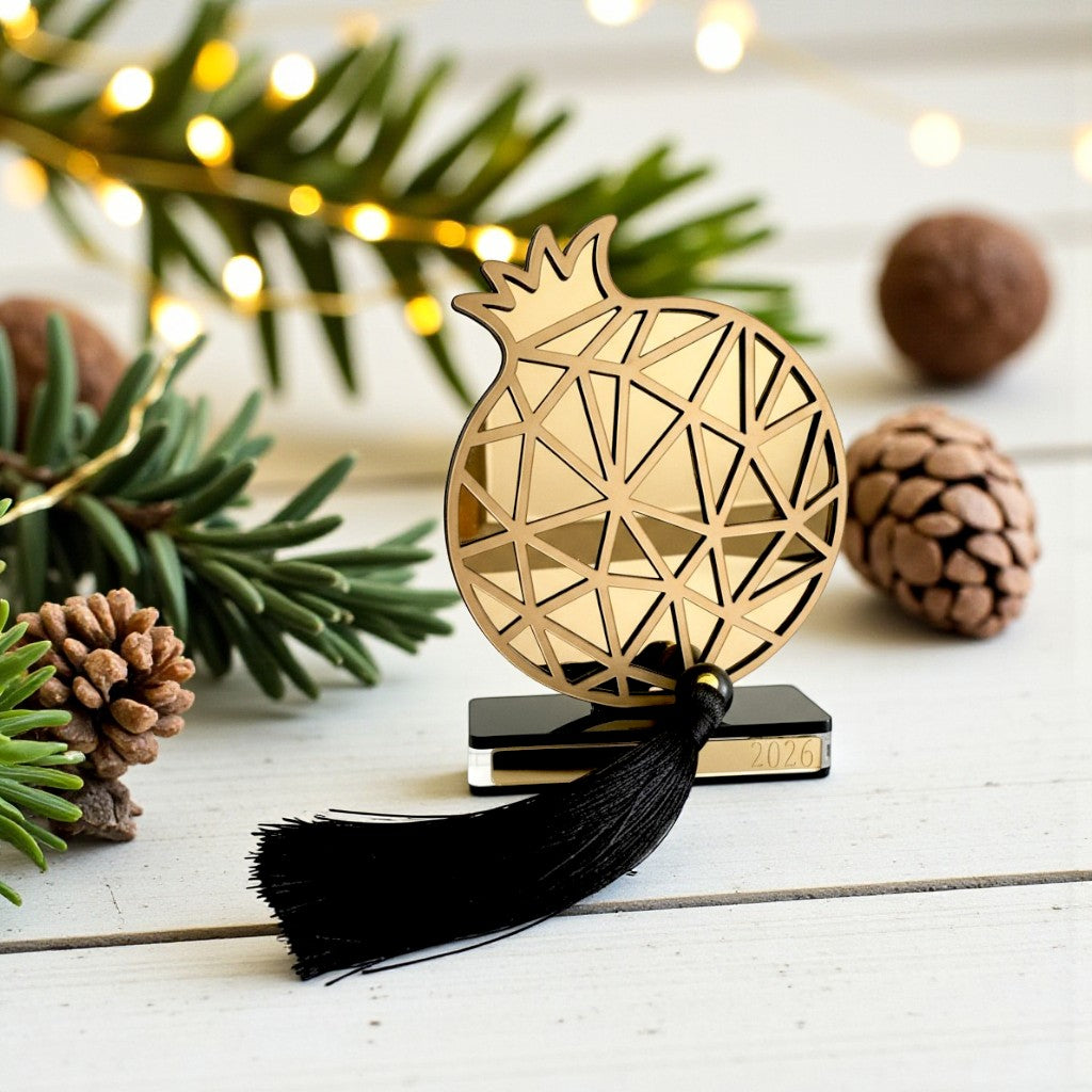 Plexiglass γούρι Ρόδι Symbolic Luxe 2026 σε χρυσό ή ασημί καθρέφτη με μαύρη βάση και φούντα — So Cute by Dimi Wholesale