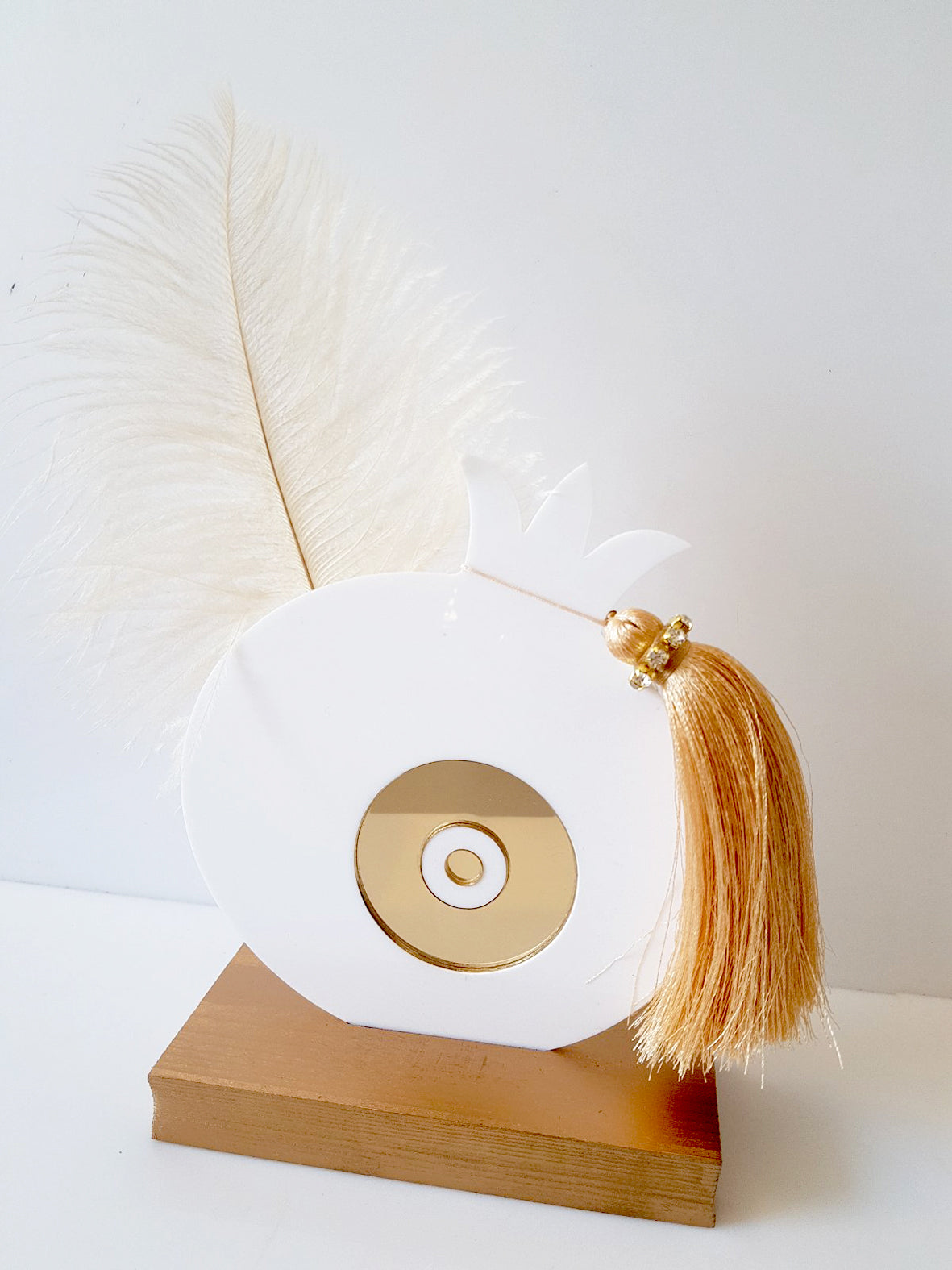 Χειροποίητο επιτραπέζιο γούρι ρόδι από plexiglass με χρυσό mirror μάτι, φτερό και φούντα με στρας, σε ξύλινη βάση, διαστάσεων 17×13 cm