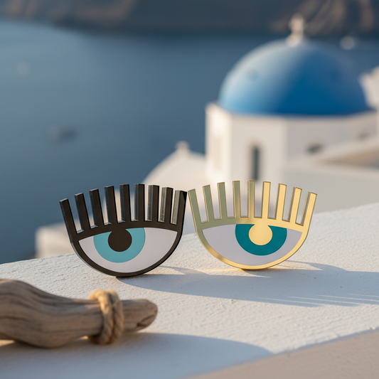 Close-up of handmade plexiglass evil eye charm against Aegean sea view in Cycladic architecture – So Cute by Dimi.