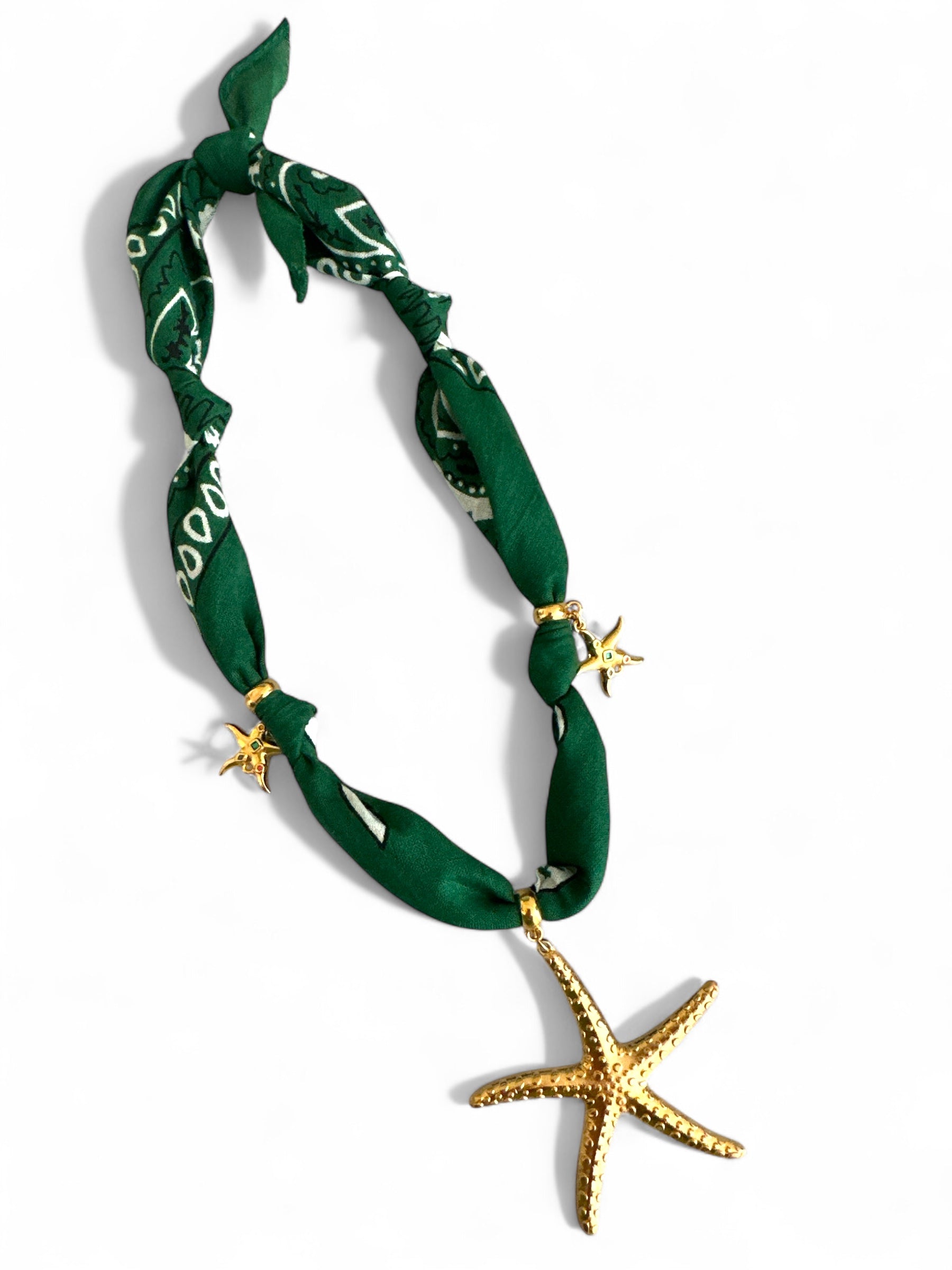 Green bandana necklace with gold starfish decorations on a white background