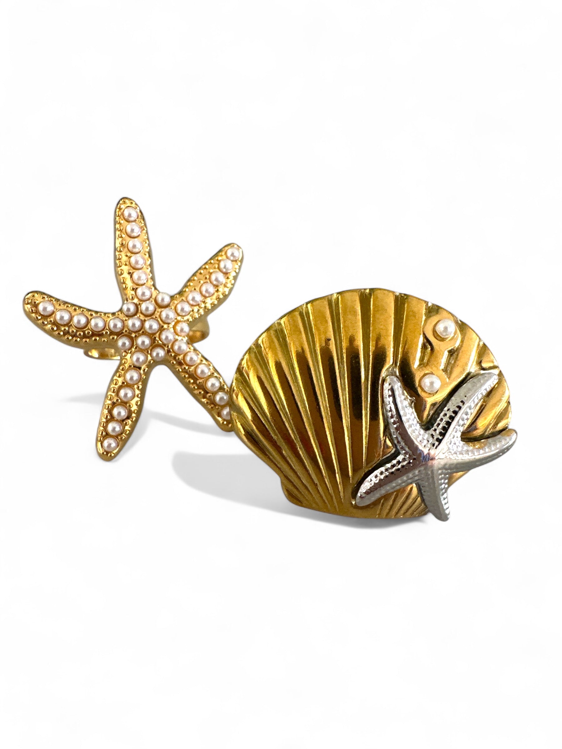 Gold starfish and shell rings on a white background