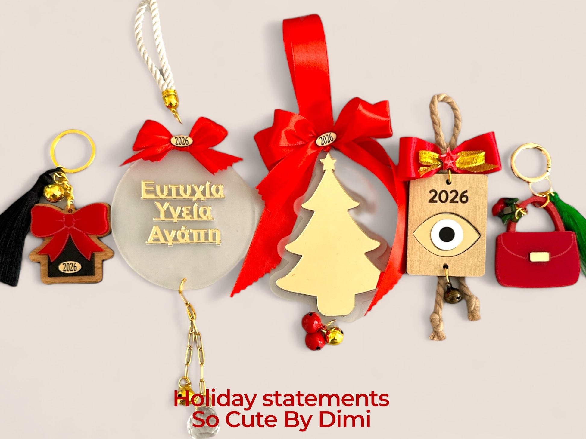 Χειροποίητα γούρια 2026 Holiday Statements So Cute By Dimi – plexiglass και ξύλο με μάτι, ευχές, τσάντα και σπιτάκι, στολισμένα με φούντες, φιογκάκια και κρυστάλλους.